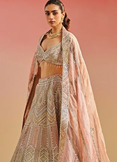 Featuring an enchanting salmon pink organza blouse, adorned with intricate gota patti, mirror work and playful tassels. Elegantly paired with a pink lehenga fully embellished with gota and mirror work and a matching multi shaded ethereal organza dupatta with mirror embellishments. Composition : Organza Care: Dry Clean Only and Vacuum Storage This product can be customized for sleeves, length of blouse and neckline Delivery : 6-8 weeks as the product is hand crafted. Check Size Guide or choose MySize for free customisation (All Sizes above XL can be made at 15% additional cost) For more information and sizes please contact fabiliciousfashion@gmail.com or visit our Copenhagen studio. Studio Iris, Cancan Lehenga, Geometric Mirror, Mirror Work Lehenga, Embroidery Mirror, Organza Embroidery, Organza Lehenga, Mirror Embroidery, Organza Blouse