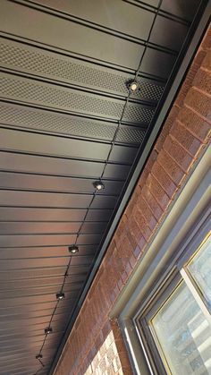 a close up of a ceiling with lights on it and a brick building in the background