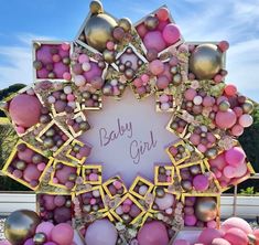 there is a baby girl sign surrounded by balloons and other items in the shape of a star