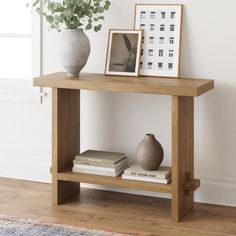 a wooden table topped with books and a vase