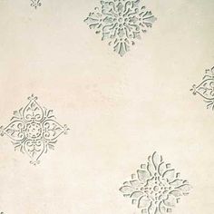 four snowflakes are shown on a white wallpapered surface with blue and green designs