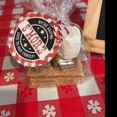 a table topped with cookies and marshmallows on top of a red checkered table cloth