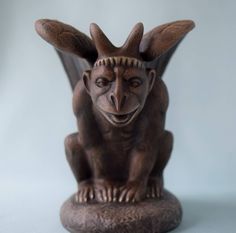 a statue of a demon sitting on top of a table