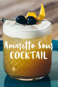 there is a glass with some liquid and lemon wedges on it that says amaretto sour cocktail