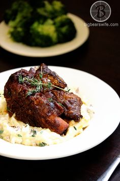 a white plate topped with meat and mashed potatoes