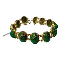 A very rare and wonderful antique Egyptian Revival Bracelet with 12 Iridescent Green Enamel Scarab Beetles. The jewel an Egyptian Revival piece dating to circa 1860 - 1930. It is very rare to find these bracelets set with the gorgeous iridescent green beetles! The scarabs are set in a low karat or gold filled setting. For centuries, Ancient Egypt has held the fascination of the public and continues to inspire artists and designers alike. With the discoveries of Egyptian tombs, and the treasures Freckled Skin, Innocent Rouge, Scarab Jewelry, Egyptian Jewellery, Egyptian Accessories, Egyptian Bracelet, Egyptian Revival Jewelry, Modern Bangle, Green Beetle