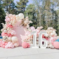 a large balloon arch with balloons in the shape of letters and numbers for a 16th birthday party