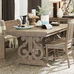 a dining room table with chairs and plates on top of it in front of a window