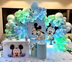 a table topped with balloons and mickey mouse decorations