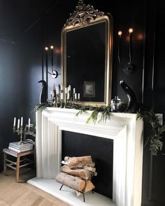 the fireplace is decorated with greenery, candles and an ornate mirror over it's mantle