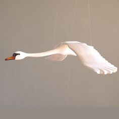 a large white bird flying in the sky with strings attached to it's wings