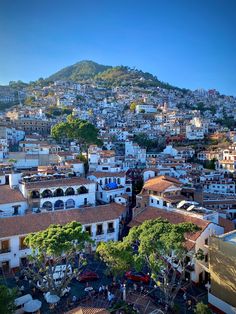 an aerial view of a city with lots of buildings and mountains in the background,