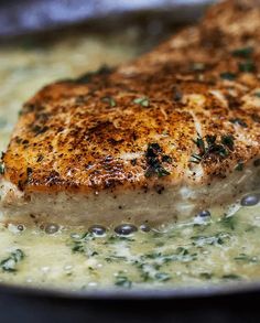 a piece of meat is being cooked in a skillet