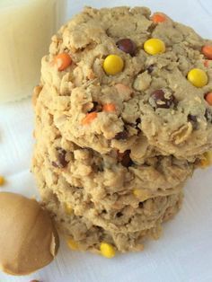 cookies and candy are stacked next to a glass of milk