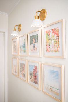 a wall with pictures hanging on it and two lights over the top of each one