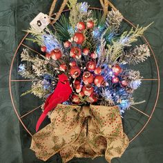 a red bird sitting on top of a christmas wreath