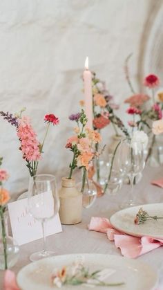 the table is set with flowers and candles