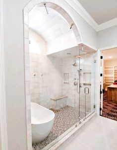 a white bath tub sitting next to a walk in shower