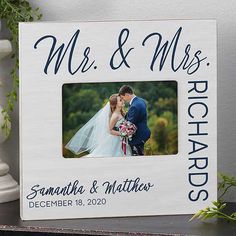 a wedding photo frame with the words mr and mrs on it next to a potted plant