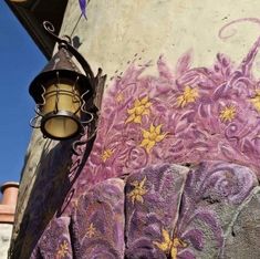 an elephant painted on the side of a building next to a street light and lamp