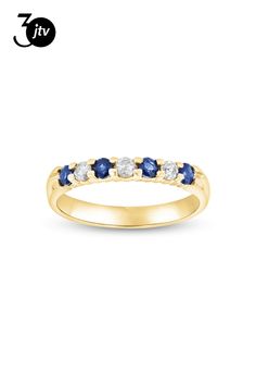 a yellow gold ring with blue and white stones on the side, in front of a white