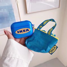 a person holding a small blue bag with a yellow ikea tag on it's side