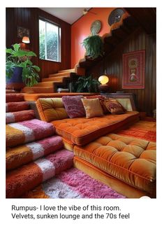 an orange couch sitting on top of a carpet covered floor next to a stair case