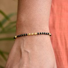 "Single strand gold chain bracelet with black beads and gold balls, handcrafted with love and care, this comfortable bracelet is a perfect accessory for everyday wear. Lightweight and stylish..! * Length : 5.5\" to 9\" + 0.5\" extender eg : 6\" length will fit wrist size of 6\"- 6.5\" * Gold : 18k Solid Yellow Gold * Gold Weight - 2.5 gms approx for 5.5\" inches with extender - For longer/shorter length, please ask for a quote before placing the order. If you like this bracelet, please press \"P Gold Bracelet Indian, Plain Gold Bangles, Mangalsutra Bracelet, Bracelet Indian, Black Hills Gold Jewelry, Diamond Pendants Designs, Black Beaded Bracelets, Indian Jewellery Design Earrings, Mangalsutra Designs