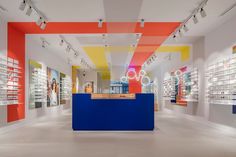 the inside of a store with many shelves and glasses on display in front of them