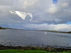 the reflection of sailboats on the water is shown