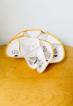 a wooden table topped with lots of white and yellow dishes on top of each other