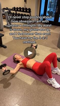 a woman laying on top of a purple mat with a barbell in front of her