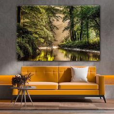 a living room with an orange couch and large painting on the wall above it's head