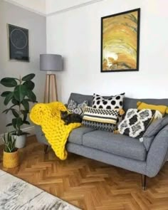 a living room filled with lots of furniture and pillows on top of a hard wood floor