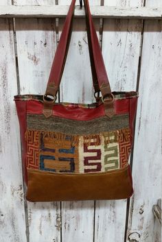 "I made this tote from a mix of Peruvian textiles on the front, and a border of Camel brown leather on lower part, and a strip of deep red leather at the top, with free form stitching. Back has a panel of vintage upholstery fabric, with the camel leather at bottom, and  the red leather strip at the top. A nice large back pocket from the camel leather with free form stitching and a lovely heart!! A deep red leather gusset around sides measures 4\" wide, providing depth and roominess. Strap handle Burgundy Tote Shoulder Bag With Leather Handles, Burgundy Leather Handled Tote Shoulder Bag, Red Shoulder Bag With Leather Trim For Travel, Rectangular Hobo Bag With Leather Trim, Red Rectangular Shoulder Bag With Leather Trim, Red Bags With Leather Trim For Travel, Red Shoulder Bag With Leather Handles For Market, Red Travel Bags With Leather Trim, Red Tote Bag With Leather Handles