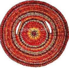 an orange and red circular rug on a white background