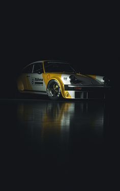 a yellow and white race car in the dark