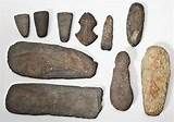 an assortment of stone tools displayed on a white surface