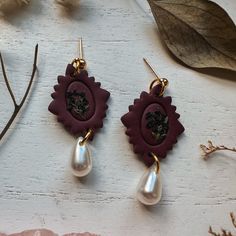 Handmade polymer clay floral frame earrings with pearl colored teardrop beads. Dark Cottagecore style clay earrings, perfect for a whimsical touch to any outfit! These clay flower earrings are created from high quality clay and are nickel free. These earrings are super lightweight! They also make the perfect subtle statement earrings! ** FIND SIMILAR EARRING STYLES HERE: https://www.etsy.com/shop/AmberRaeStudio?ref=simple-shop-header-name&listing_id=1243178562 * Nickel Free * Super Lightweight Dark Academia Accessories Earrings, Dark Academia Floral, Whimsigoth Jewelry, Cottagecore Accessories, Clay Flower Earrings, Trendy Stud Earrings, Edgy Earrings, Dark Cottagecore, Cottagecore Style