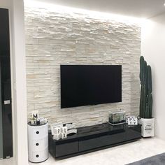 a living room with a large flat screen tv mounted on the side of a wall