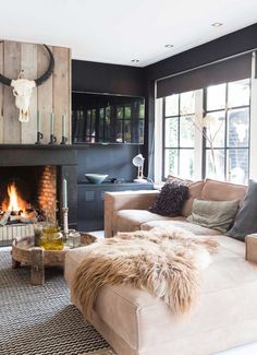 a living room filled with furniture and a fire place in front of a cow skull mounted on the wall