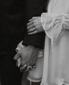 a couple holding hands while standing next to each other