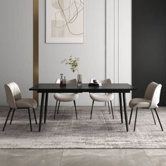 a dining room table with four chairs and a vase on the table in front of it