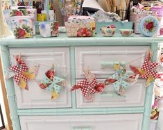 an old dresser is decorated with paper flowers and bows on the top, along with other items