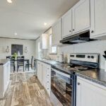 a kitchen with white cabinets and black counter tops