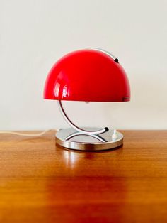 a red lamp sitting on top of a wooden table