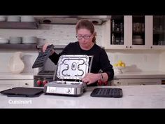 a woman is holding an open box with numbers on it in the middle of a kitchen