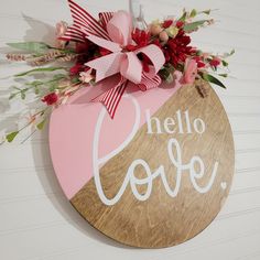 a wooden sign that says hello love hanging on the side of a wall with flowers