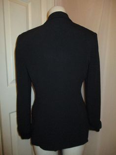 "From around the 1990's. Nicely fitted double breasted. 75% acetate, 25% rayon. Dry clean. Single button closure with interior button. Front button flap pockets. Shiny satin fabric on collar, cuffs, pocket flaps and covered buttons. It has med/large shoulder pads. Marked size 4. Runs true to size. It fits me and I wear a 4. It measures 26\" long. 23\" sleeves. 16\" across the back of the shoulders. Laying flat seam to seam it's 18\" across under the arms, 15 1/2\" at the waist. Overall very good Classic Single Breasted V-neck Outerwear, Tailored V-neck Blazer With Button Closure, Tailored V-neck Formal Outerwear, Fitted Single-breasted Long Sleeve Outerwear, Fitted V-neck Outerwear With Double Button Closure, Fitted Single-breasted Outerwear, Fitted Long Sleeve Blazer For Winter, Winter V-neck Blazer With Buttons, Fitted Long Sleeve Outerwear With Double Button Closure