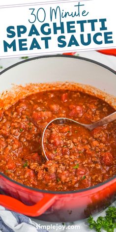 a red pot filled with meat sauce and garnished with parsley on the side